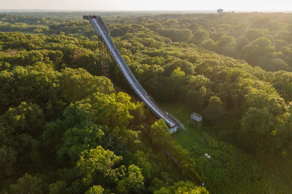 Aerial view of a slide surrounded by lush green forest in Bloomington, Minnesota during a sunny day.